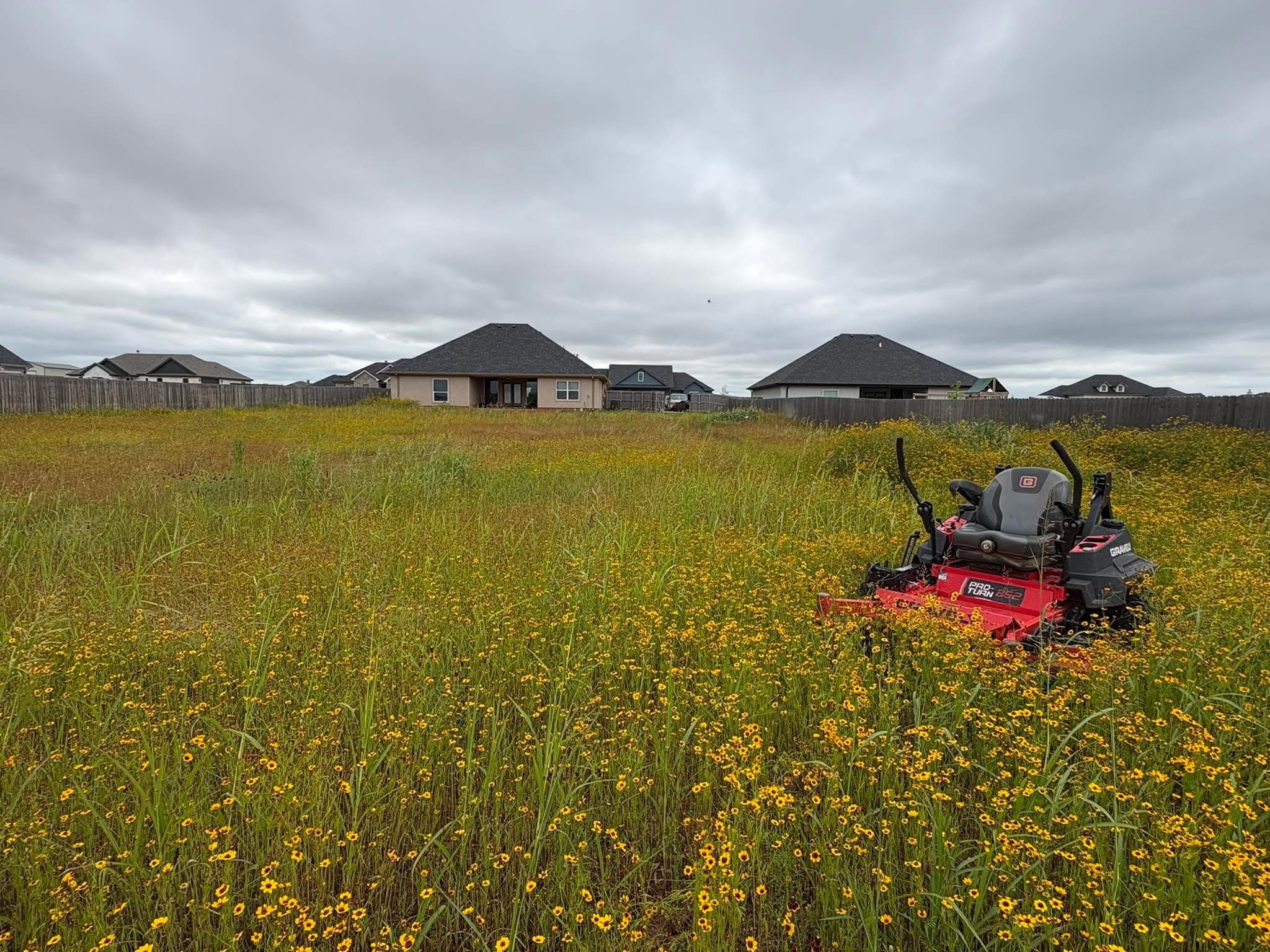 Red Outwest commercial mower ready to cut an overgrown Abilene property