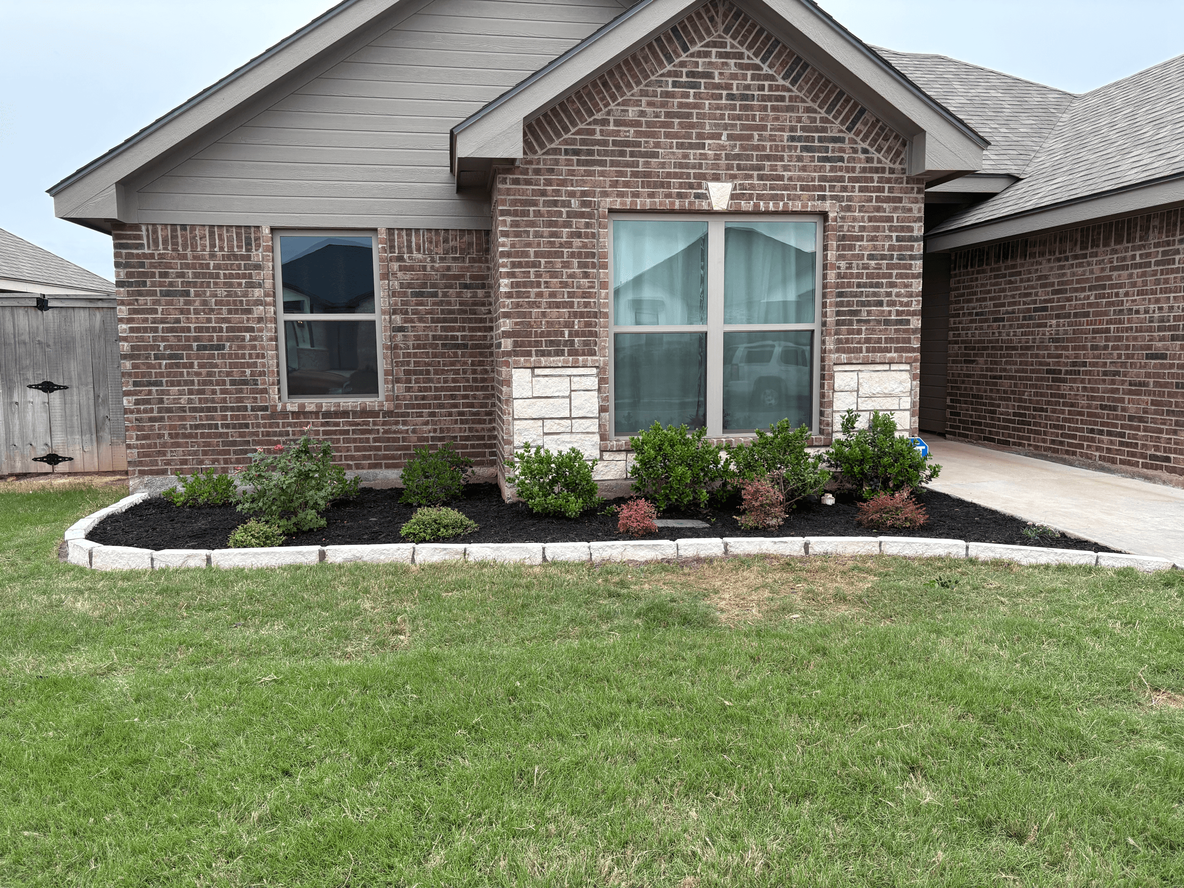 Freshly mulched landscape bed with a defined stone border